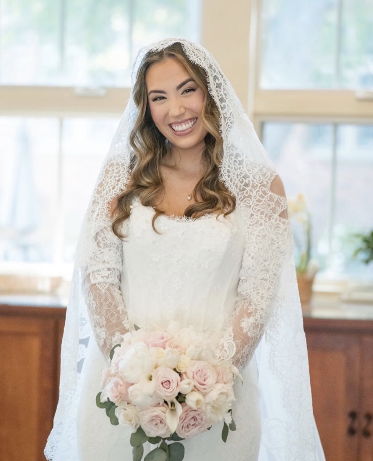 Smiling bride holding a bouquet in soft radiant bridal makeup