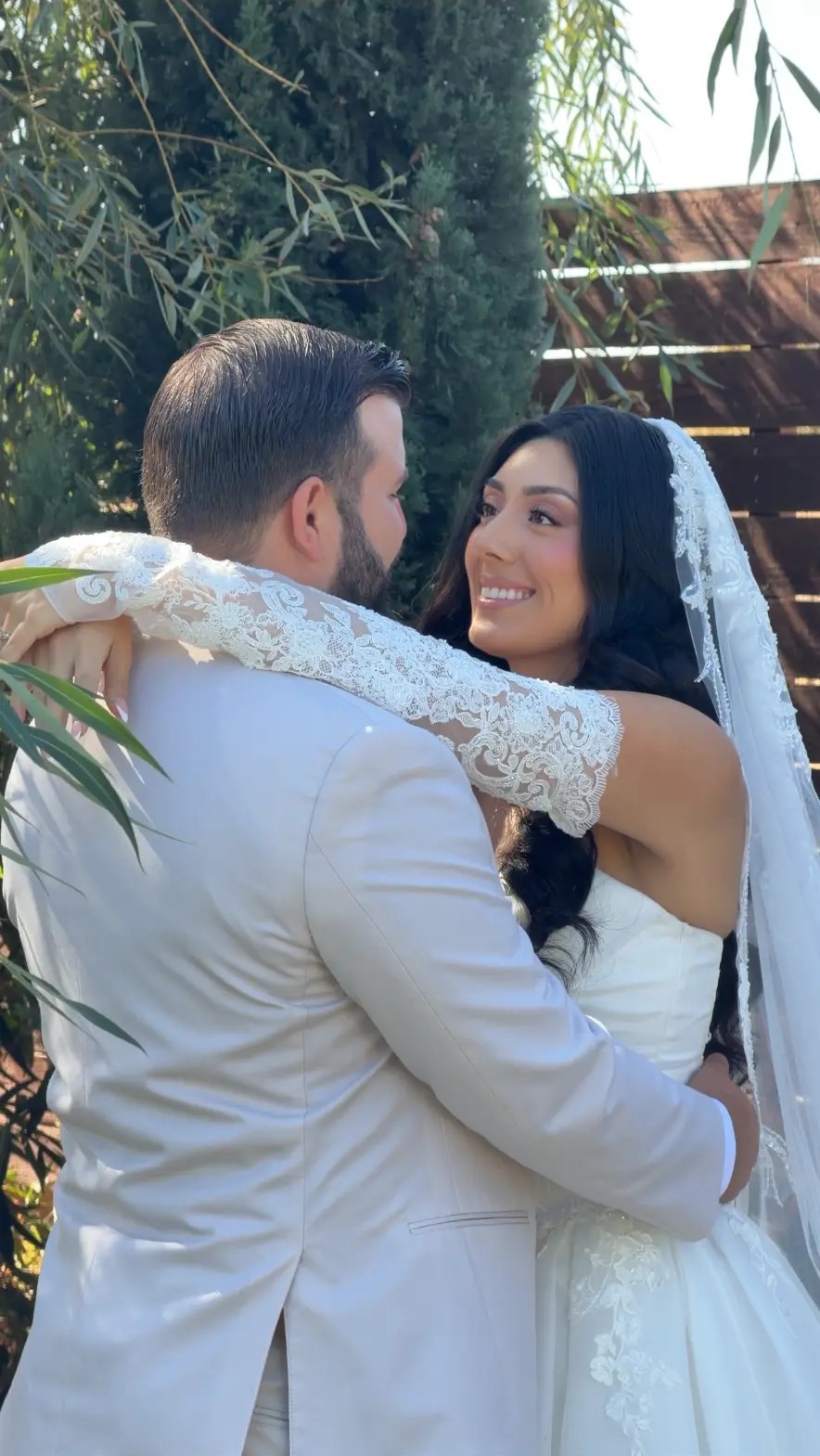 Bride embracing her groom on their wedding day with soft glam bridal makeup by Maddy Donohue